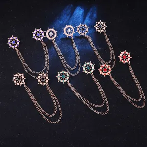 Detailed close-up of nautical helm collar pins featuring sparkling rhinestones and double chains.