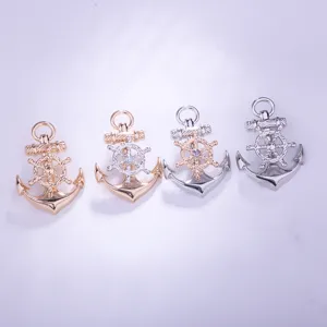 Detailed view of four metal alloy anchor and ship wheel brooches in gold and silver colors.