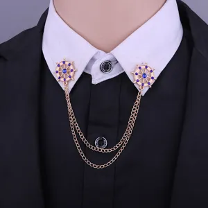 Close-up detail of gold-tone helm collar pins with double chains and blue rhinestones.