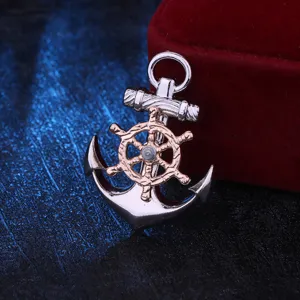 Detailed shot of a rotatable steering wheel and anchor brooch in silver and rose gold.