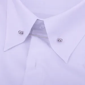 Metalen kraagspeld detail met zilveren kogelvormige uiteinden op een witte overhemdkraag.