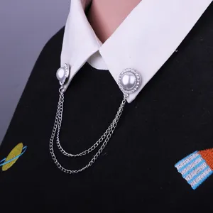 Close-up detail of silver alloy rhinestone pearl double chain shirt collar pin brooch accessory.