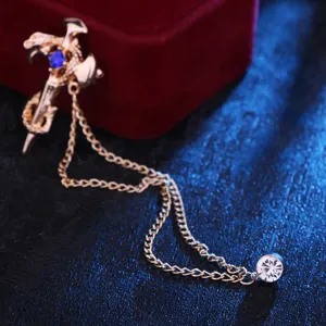 Goudkleurige zwaard slang broche met bungelende kettingen en kristallen strass voor.