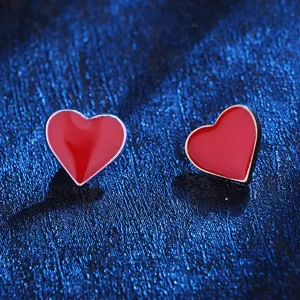 Red heart enamel metal stud earrings or lapel pins, vibrant color, fashionable accessories.