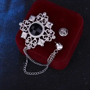 Nahaufnahme der retro hohlen Brosche mit schwarzem Edelstein und Kette, eleganter Schmuck.