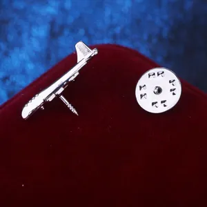 Nahaufnahme Detailaufnahme einer silbernen Flugzeug Anstecknadel mit Sicherheitsverschluss.