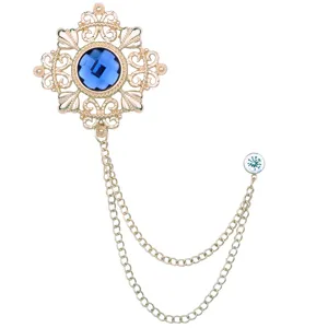 Nahaufnahme einer Vintage hohlen Blumenbrosche mit blauem Kristall und Doppelkette.