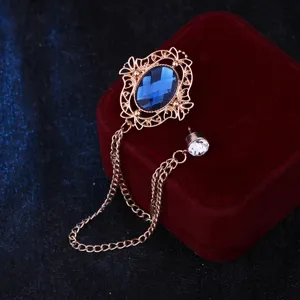 Vintage style retro court hollow blue gemstone brooch detail shot with delicate chain design.