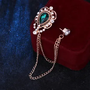 Detailaufnahme der vintage hohlen tropfenformigen Brosche mit gruener Kristall und Kette.