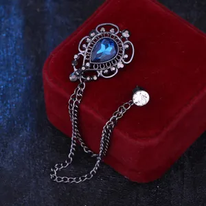 Detailaufnahme einer dunklen Vintage-Tropfenkristallbrosche mit Ketten und Strass.