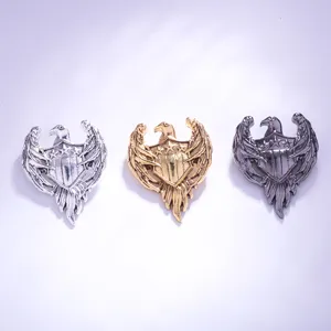 Retro eagle shield metal brooches detail shot, showing silver, gold and dark gunmetal finishes.