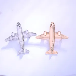 Primer plano detallado del broche con forma de avión vintage en acabado de metal plateado.