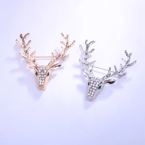 Vista dettagliata di due eleganti spille a testa di cervo con strass oro e argento.