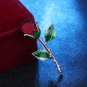 Exquisite fabric rose brooch with green enameled leaves and gold stem for evening party dress.