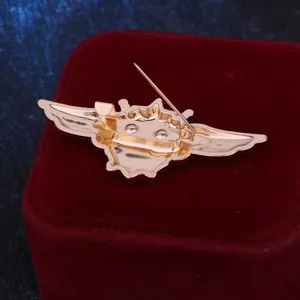 Back detail of gold flight wings brooch pin, showing secure safety clasp and durable metal.