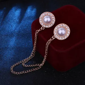Close-up detail of the elegant double brooch collar pin with sparkling rhinestones and pearl.