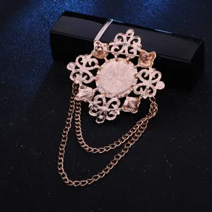 Vintage roségouden brochespeld met hangende kettingen voor heren pak accessoire detailopname