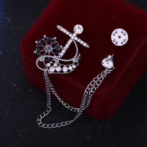 Vista detallada del broche de ancla y timón para hombre con cadena y pedrería de brillantes.