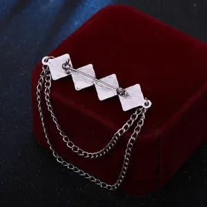 Nahaufnahme der Herren Metallbroche mit geometrischem quadratischem Design und doppelten Quastenketten.
