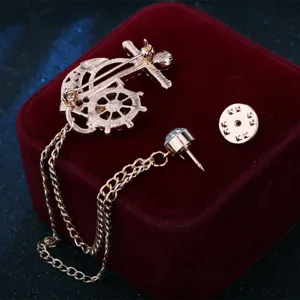 Primer plano detallado del broche marinero de ancla y timón con elegantes cadenas y detalles.