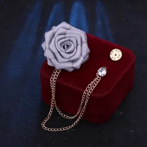 Graue Stoffrosen Brosche mit Goldquastenkette und Strass, elegantes Accessoire für Anzüge.
