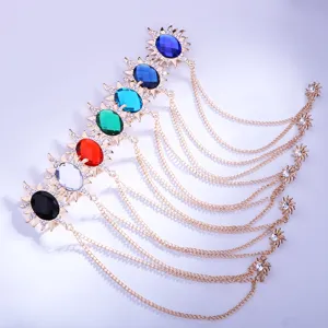 Detailansicht der funkelnden Sonnenform Strass Brosche mit goldenen Ketten und Edelsteinen.