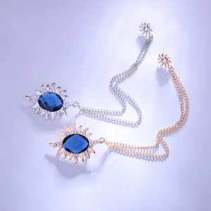 Detailansicht der Sonnen-Brosche mit Kette, blauem Schmuckstein und funkelnden Zirkonia.