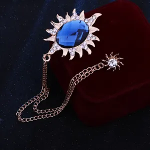 Detailansicht der luxuriösen Strass Sonnembrosche mit blauem Edelstein und Kette für Herren.