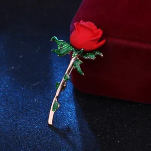 Elegante rote Rosen Brosche mit glitzernden grünen Kristallblättern und Roségold Stiel im Detail.