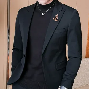 Gros plan détaillé d'une broche cœur ancre en or rose épinglée sur le revers d'un costume noir.
