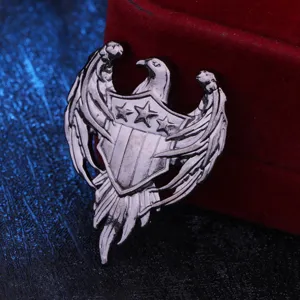 Close-up detail of vintage silver eagle shield brooch, retro metallic pin badge
