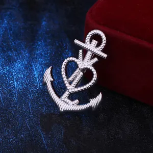 Vue rapprochée de la broche ancre argentée avec un design de cœur délicat et texture brillante.