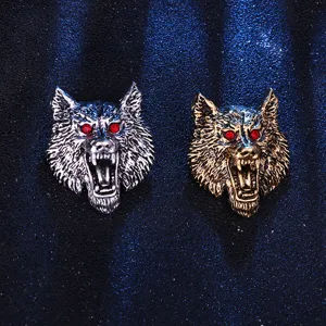 Detailansicht von Vintage Wolfskopf Broschen mit roten Kristallaugen in Silber und Bronze.