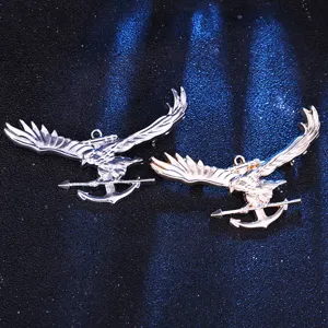 Primer plano detalle de broches de águila y ancla de metal con acabados en plata y oro.