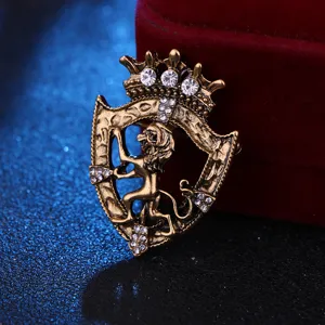 Spilla vintage color oro con leone e scudo, strass di cristallo scintillanti e corona regale.