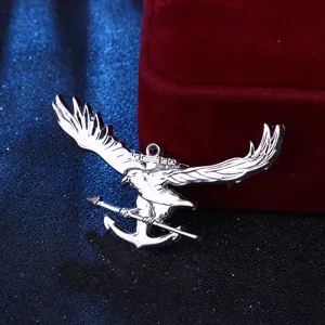 Primer plano detallado de un broche de plata águila y ancla, elegante joya marinera masculina.