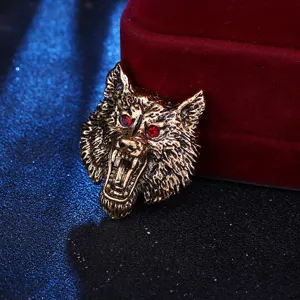 Detaillierte Nahaufnahme einer Vintage-Bronze-Tierbrosche mit brüllendem Tierkopf und roten Kristallaugen.