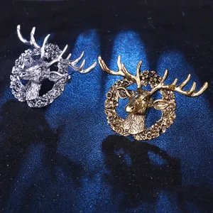 Close-up view of vintage elk head brooch, detailed floral wreath metal alloy pin design.