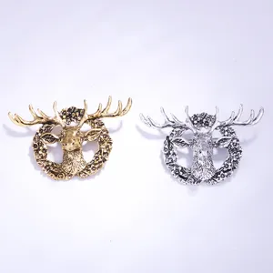 Close-up view of vintage elk head alloy brooch, antique gold and silver finish, detailed design.