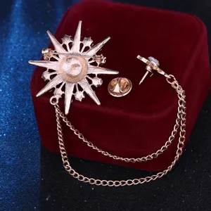 Detailansicht der goldfarbenen Stern-Brosche mit doppelten Ketten und sicherem Pin-Verschluss.