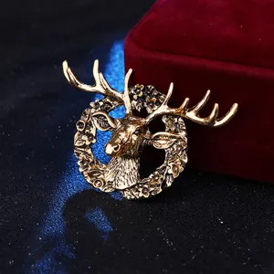 Close-up view of vintage golden deer head brooch pin, detailed floral wreath metal badge design.