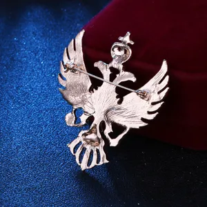 Detailaufnahme der goldenen Doppeladler Brosche mit sicherer Anstecknadel auf rotem Samt.
