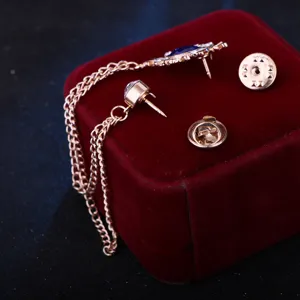 Detailansicht einer stilvollen Quastenketten Brosche Kragennadel mit blauem Stein Strass.