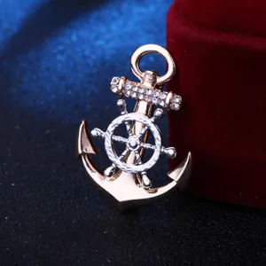Gros plan detaille d'une broche elegante en metal en forme d'ancre et de gouvernail avec cristaux.