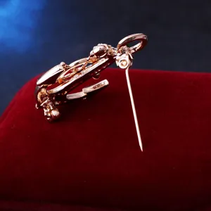 Détail de broche ancre et gouvernail en or rose, montrant un fermoir de sécurité.