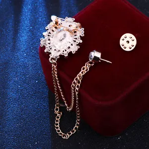 Detailed view of vintage court style brooch with hanging chain and gem on red velvet box.