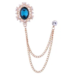 Vintage gold court style brooch with deep blue rhinestone and double hanging chains accessory.