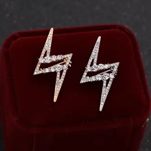 Close-up detail shot of exquisite rhinestone lightning bolt brooches in gold and silver tones.