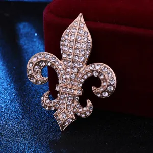 Close-up detail of a stunning gold-tone rhinestone fleur-de-lis brooch accessory.