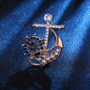 Primer plano detallado de un elegante broche de estrás con diseño de ancla y timón.